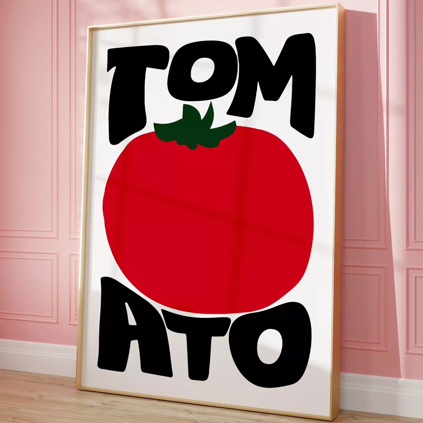 白地にモダンな黒字で「TOMATO」の文字を「TOM」と「ATO」に分け、その間に大きな赤いトマトのイラストをあしらったミニマルなアートプリント。緑の葉がアクセントとなり、シンプルながらインパクトのあるデザイン。