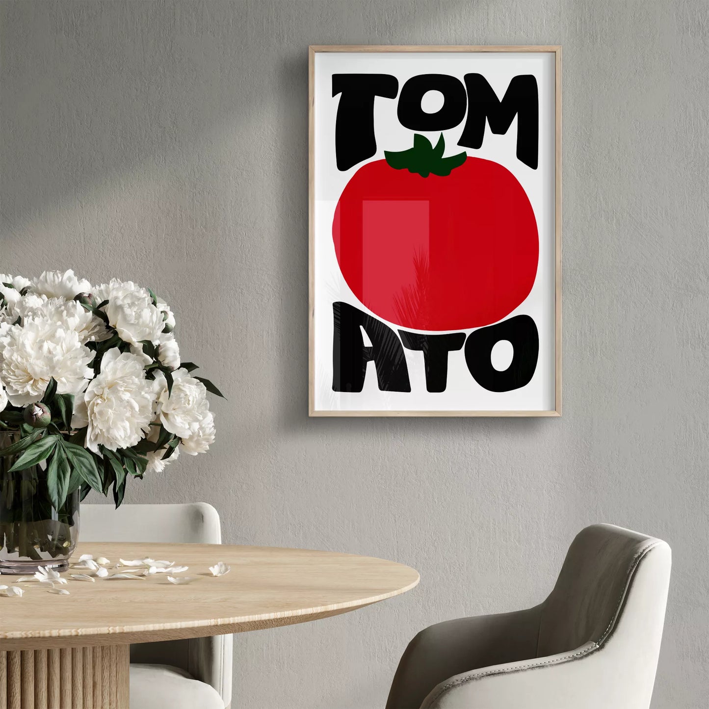 白地にモダンな黒字で「TOMATO」の文字を「TOM」と「ATO」に分け、その間に大きな赤いトマトのイラストをあしらったミニマルなアートプリント。緑の葉がアクセントとなり、シンプルながらインパクトのあるデザイン。