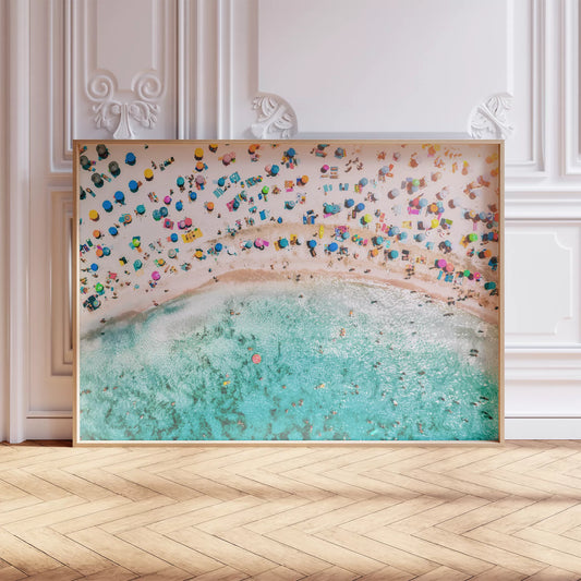 鮮やかな青い海とカラフルなパラソルが広がるビーチの空撮風景