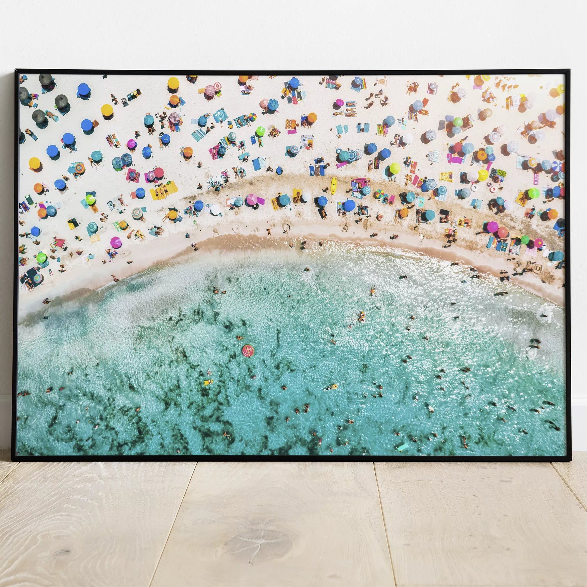 鮮やかな青い海とカラフルなパラソルが広がるビーチの空撮風景