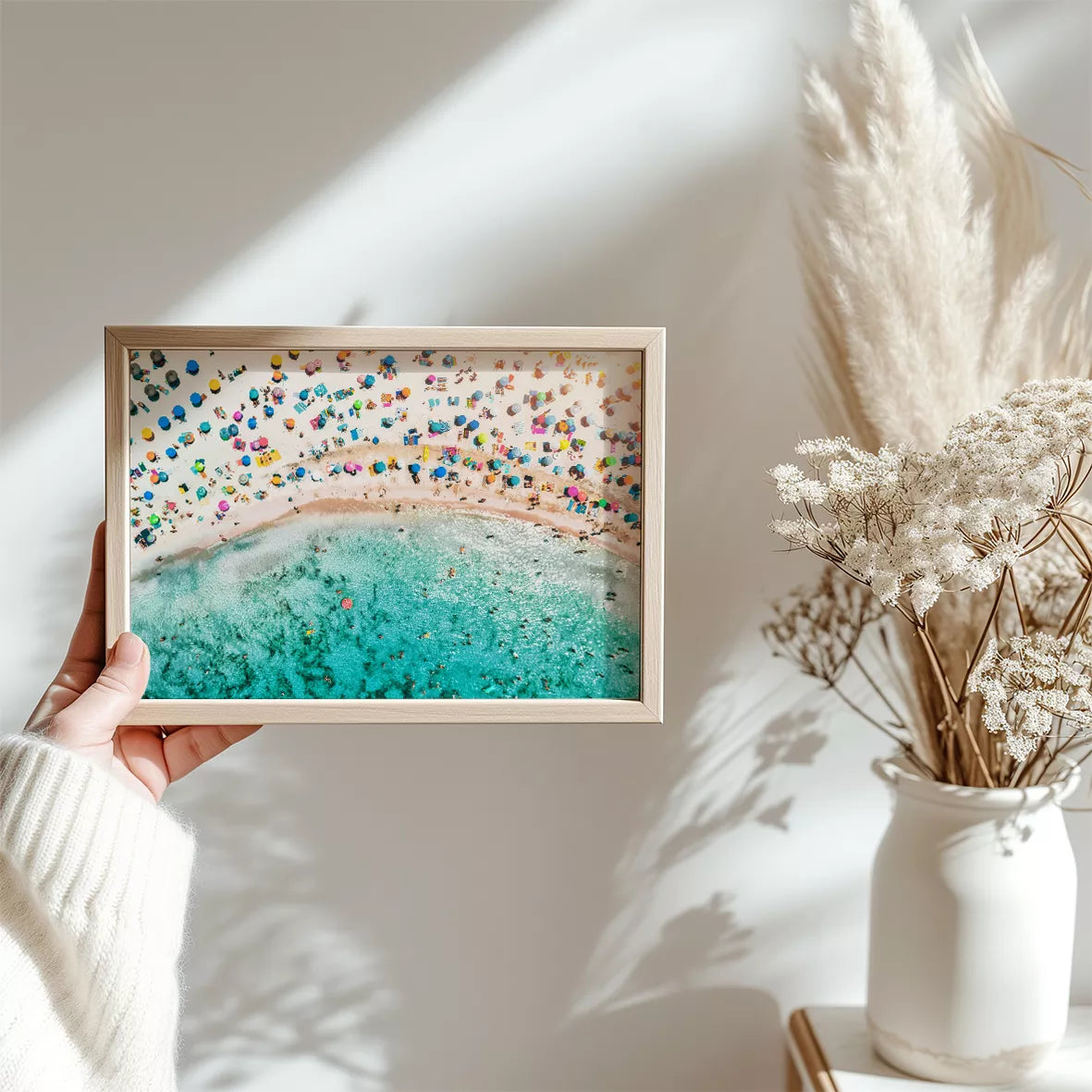 鮮やかな青い海とカラフルなパラソルが広がるビーチの空撮風景