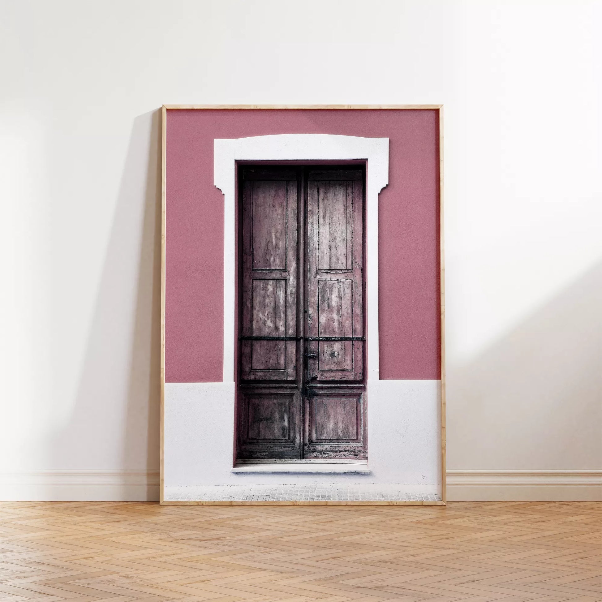 ピンク色の壁に映える木製アンティークドアのアートプリント