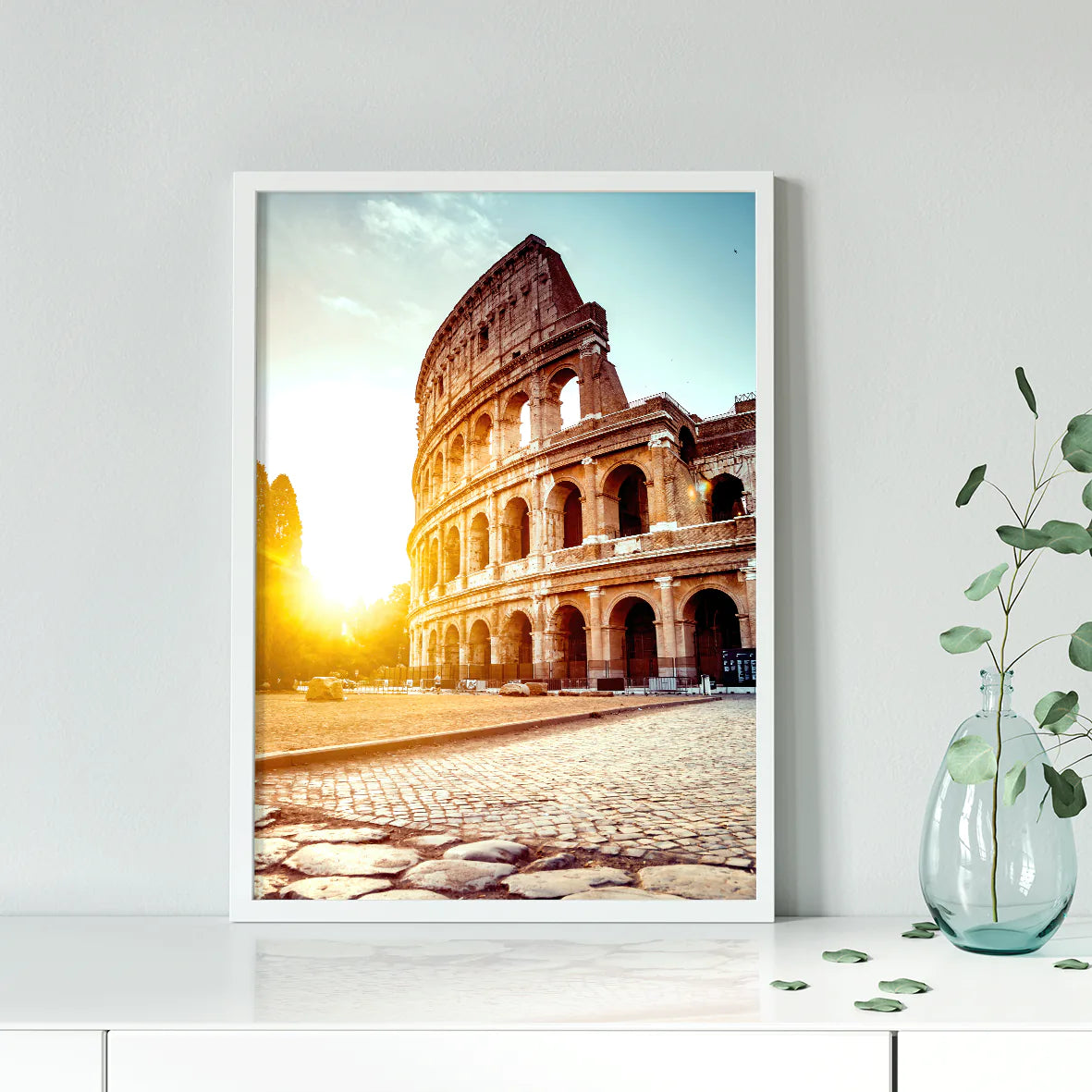 Wall art of the Colosseum in Rome with the sun rising behind it