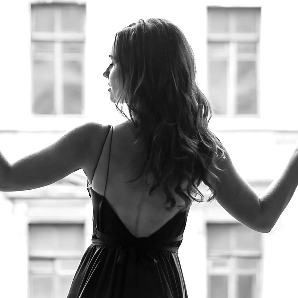 Elegant lady in silhouette against the bright light of an open window