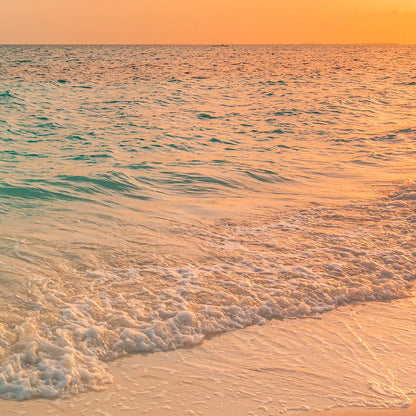 Breathtaking beach sunset wall art with the sun setting over a calm ocean, reflecting warm colors on the water.