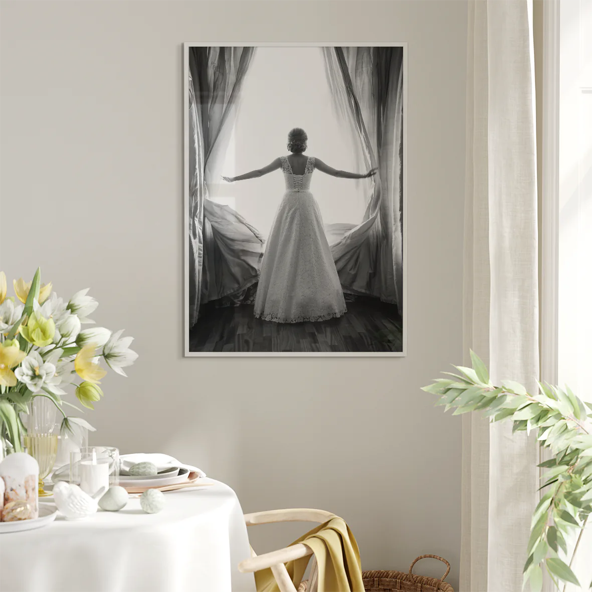 Black and white image of a bride in a lace wedding dress standing at an open window