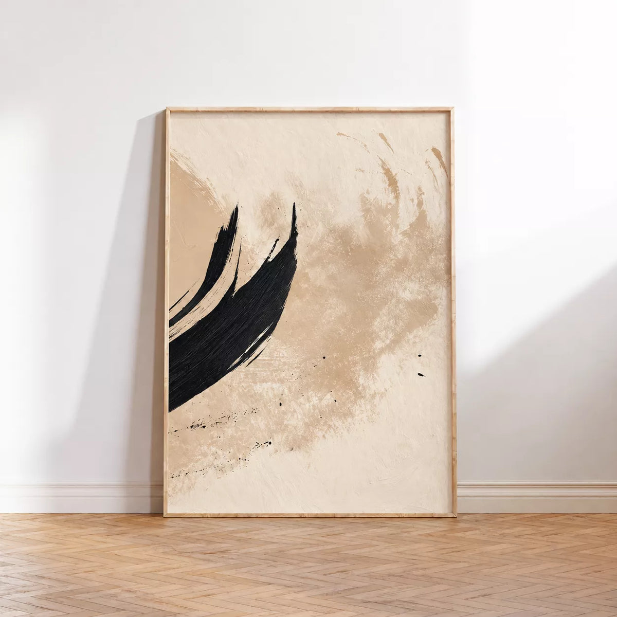 白い壁と木床に立て掛けたベージュと黒の上向きの筆タッチの抽象画