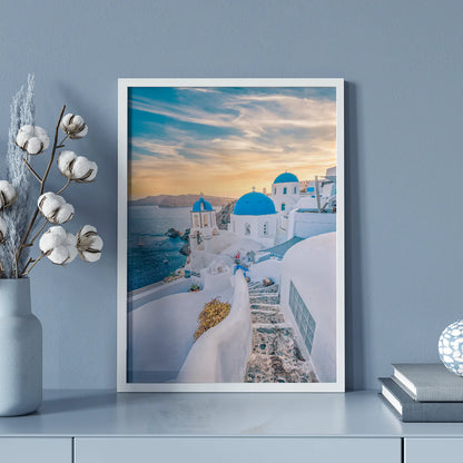 Wall art capturing the beauty of Santorini's sunset with blue domes and whitewashed buildings against a pastel sky