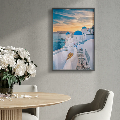 Wall art capturing the beauty of Santorini's sunset with blue domes and whitewashed buildings against a pastel sky