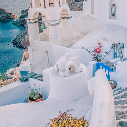 Wall art capturing the beauty of Santorini's sunset with blue domes and whitewashed buildings against a pastel sky