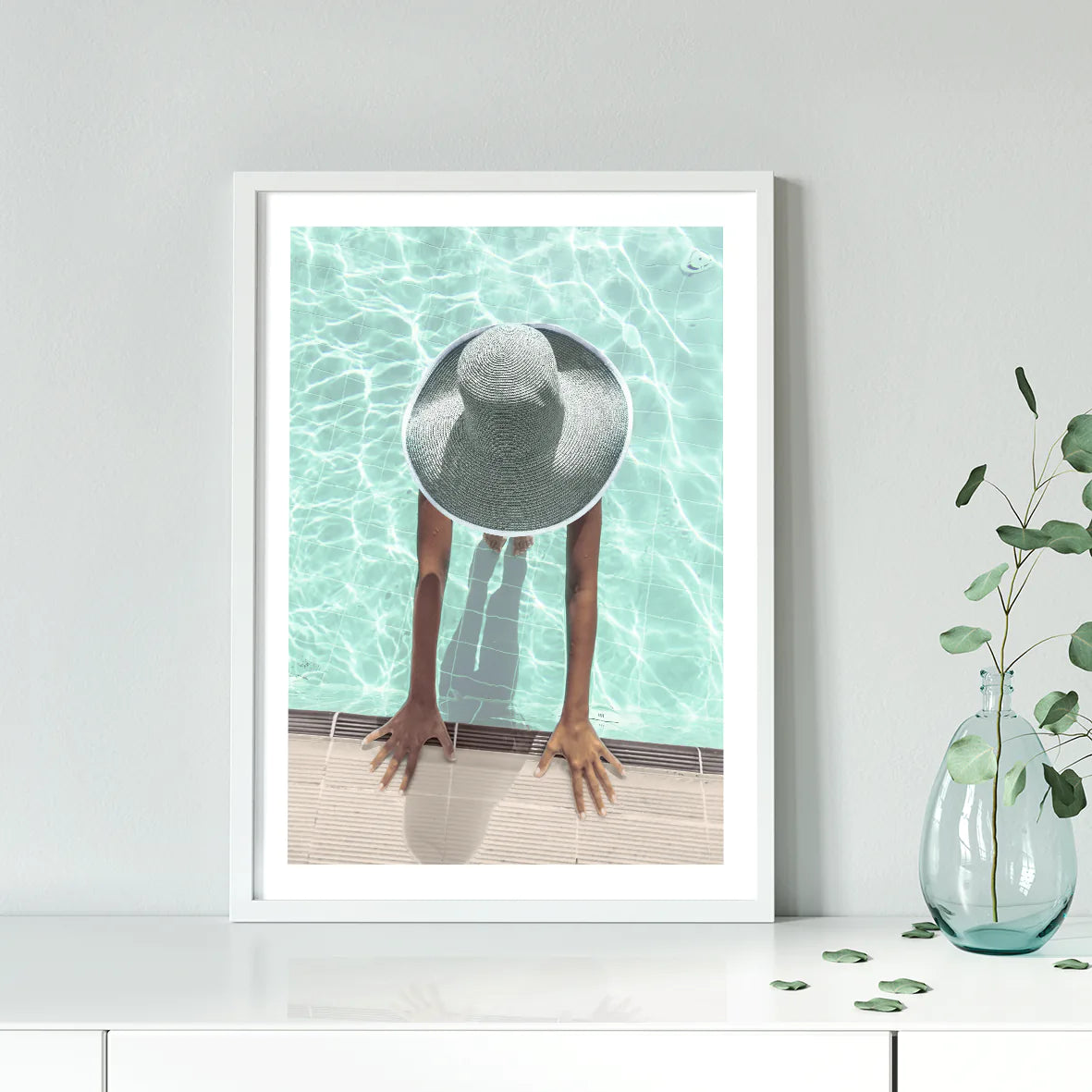 Elegant wall art showcasing a tranquil pool scene with a sunhat-clad figure,