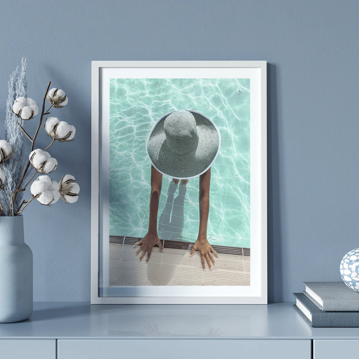 Elegant wall art showcasing a tranquil pool scene with a sunhat-clad figure,