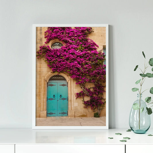 Turquoise door with vibrant purple flowers on a building facade