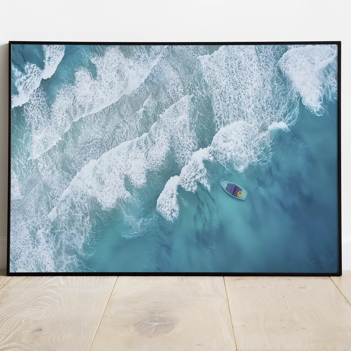 エメラルドブルーの海と白波、静かに浮かぶ小舟の空撮アート