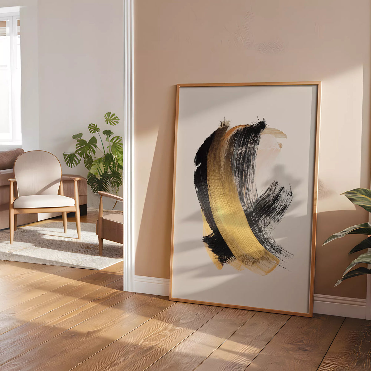 淡いベージュの部屋で木製チェアの隣に立てかけたブラックとアンバーの抽象ポスター