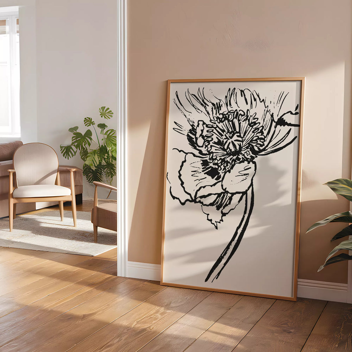 大輪の花のラインアートポスターを、チェアと植物のある暖かな色調の部屋に立て掛けたイメージ