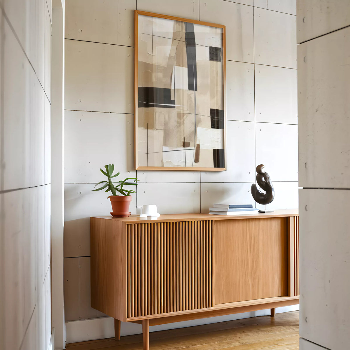 コンクリートパネルの壁と木のサイドボードに合わせて飾った、ベージュ×ブラックの抽象画ポスター