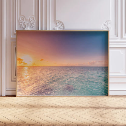 白いクラシックな腰壁の前、ヘリンボーンの床に立てかけた夕日の海のアートポスター