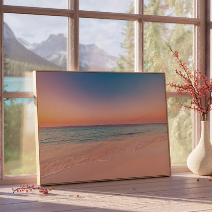 夕空と穏やかな波のポスターを、窓辺で枝ものの花瓶と合わせた展示イメージ