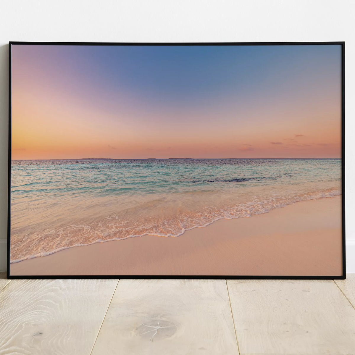 ラベンダーの夕空とターコイズの海のポスターを、黒いフレームで展示したイメージ