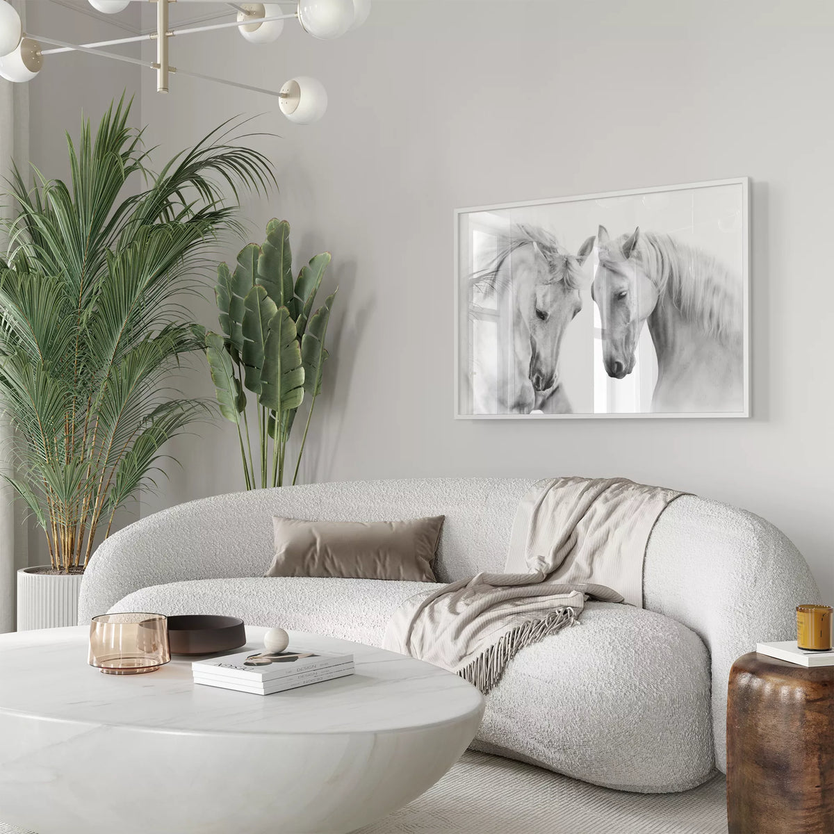 白い曲線ソファと観葉植物のあるリビングに飾った、2頭の白馬のモノクロアートポスター